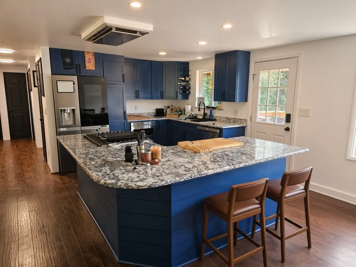 Finished open kitchen in Spenard with navy cabinets, island, and granite counters